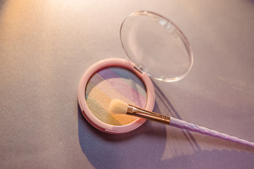 rainbow highlighter and cute twisted makeup brush close-up