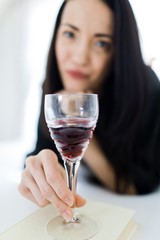 Red wine in hand of attractive woman laying on bed - Crystal glass.