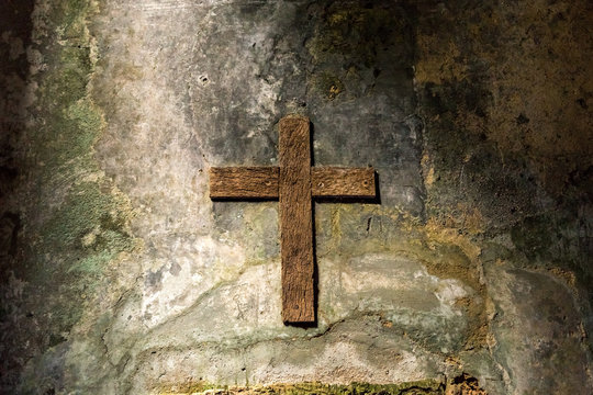 Wood cross hanging on an old grunge wall. An old chross in Convento dos Capuchos Sintra, Portugal