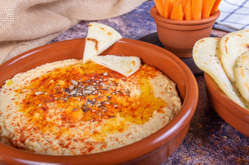 Plate of hummus with hindu bread and crudités of carrot and pepper. Vegan and vegetarian food
