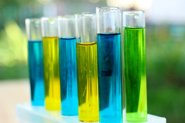 Test tubes with green, blue and yellow liquids.