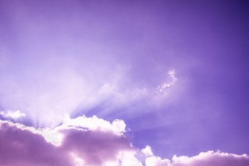 Rays of light shining up. Beam of light and the fluffy clouds. Pink purple sky with sun rays