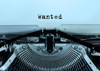 Wanted printed on a sheet of paper on a vintage typewriter . writer, journalist.