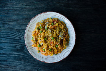 Lentil porridge with vegetables and herbs. Healthy lifestyle. Dietary menu. Dark wooden background. View from above.