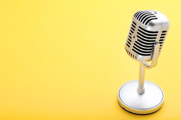 Vintage microphone on yellow background