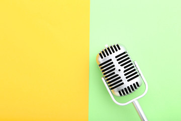 Vintage microphone on green and yellow background
