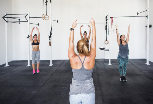 High angle view of athletes doing warm up exercises in gym