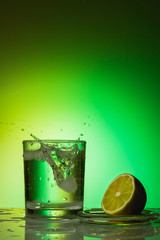 Splashes in a glass of water on a colored background