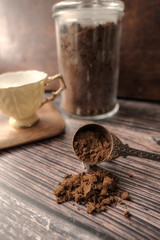 Powdered coffee and mug on wooden background