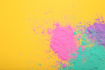 Fototapeta na wymiar Colorful holi powders on yellow background