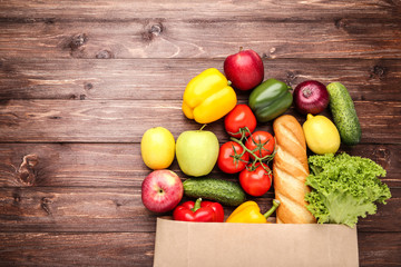 Grocery shopping bag with food on brown wooden table