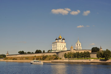 Fototapeta na wymiar View of the Trinity Cathedral in the Pskov Kremlin from the Great River, on which the ship sails on a summer evening, Russia.