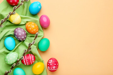 Colorful easter eggs with willow branches on beige background