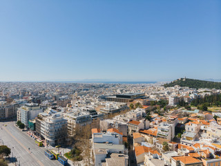 Fototapeta premium City views of day time with acropolis on a hill at the horizon, Athens, Greece
