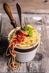 spaghetti with tomato sauce and basil, overflowing from the pot . Italian food