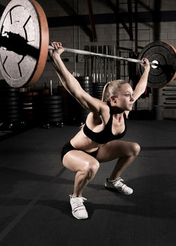 Athlete exercising with barbell at gym