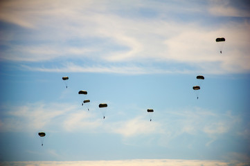 Low angle view of paratroopers flying in sky during airshow