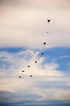 Low angle view of paratroopers flying in cloudy sky during airshow