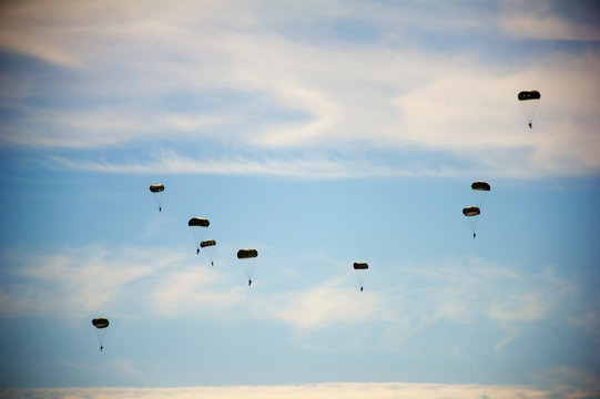 Low angle view of paratroopers flying in sky during airshow