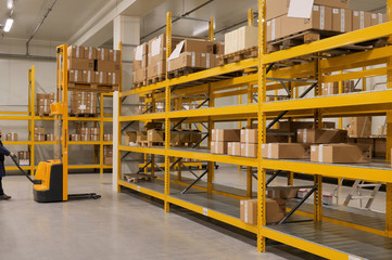 industrial warehouse with a worker who maneuvers a forklift