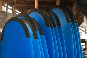 Stack of blue color soft surfboards in a stack by ocean.Bali.Indonesia. Surf boards on sandy beach for rent. Surf lessons on Weligama beach, Sri Lanka.