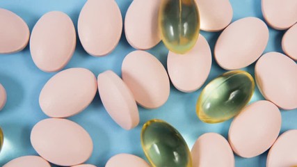 pink oval pill lie on a blue background