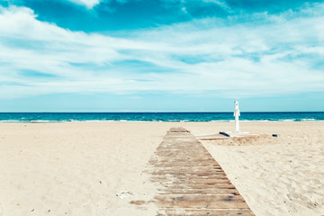 Fototapeta na wymiar wooden straight road to the sea on sand beach