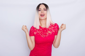 Young blonde woman over white background in bright pink dress