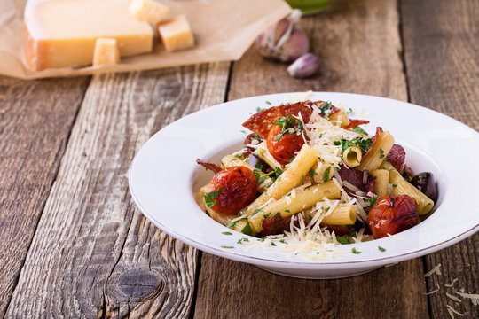 Rigatoni pasta with salami, roasted cherry tomatoes, and olives