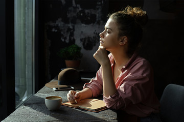 Fototapeta na wymiar Girl by the window in a cafe.