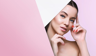 Portrait of young beautiful woman with healthy glow perfect smooth skin look into the hole of...