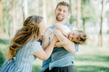 Fototapeta premium Happy young family spending time together outside in green nature
