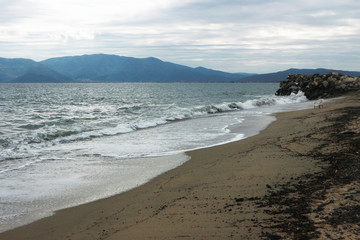 Empty seashore, grey sky and storm