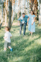Fototapeta premium Happy young family spending time together outside in green nature