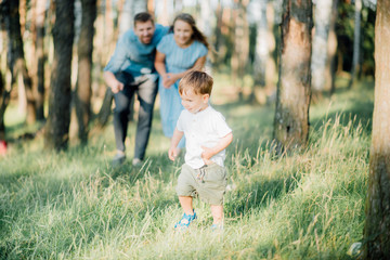 Fototapeta premium Happy young family spending time together outside in green nature