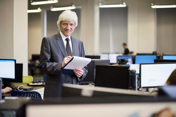 Fototapeta premium Waist up portrait of successful senior businessman posing in office and smiling at camera, copy space