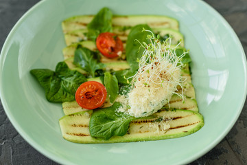 Salad from zucchini slices with cherry tomato, cream cheese and micro greens. Vegetarian food