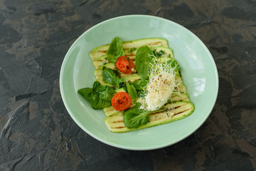 Salad from zucchini slices with cherry tomato, cream cheese and micro greens. Vegetarian food