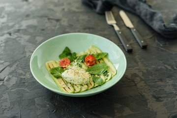 Salad from zucchini slices with cherry tomato, cream cheese and micro greens. Vegetarian food