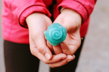 Green slime in the girl in her hands. The girl is always enthusiastically played with slime, even at school