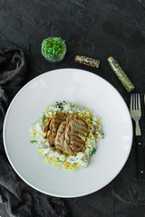 Dish with meat pieces, pasta, greens, sauce from a foie gras and the olive earth