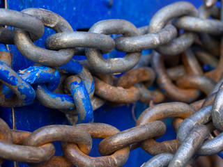 Iron big chain and hook on the blue door. The lock on the chain.