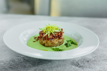 Meat dish with rice, onions slices, greens and sauce