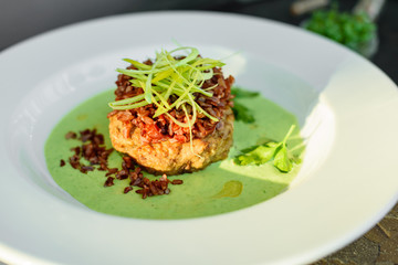 Meat dish with rice, onions slices, greens and sauce