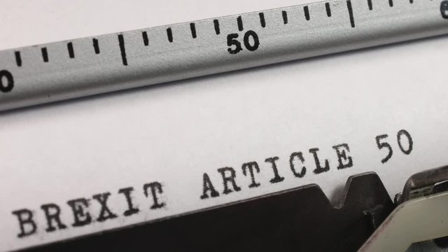 Typing BREXIT ARTICLE 50 on an old manual typewriter.