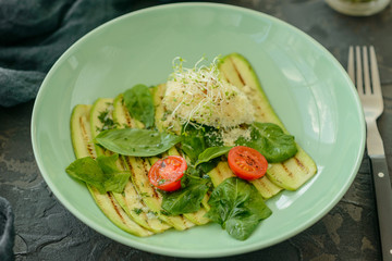 Salad from zucchini slices with cherry tomato, cream cheese and micro greens. Vegetarian food