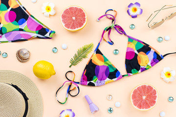 Bikini swimsuit with straw hat, flowers and fruits, flat design, summer concept. Beach destination, summer fashion