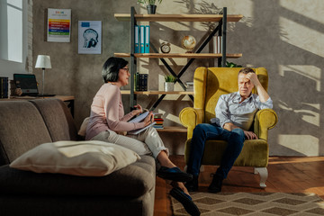 Concentrated dark-haired woman with bob haircut having important conversation