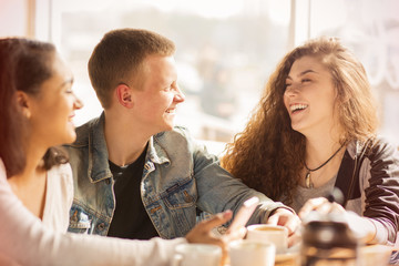 Happy friends hanging out at the cafe together
