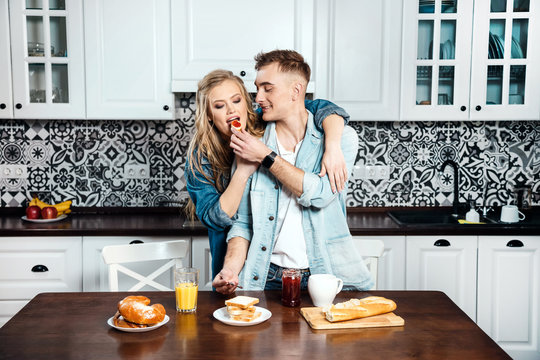 Blonde guy feeds his girlfriend toast with jam